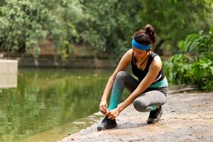 Cute Young Lady Tying Her Shoelaces photo