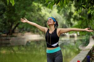 Slim Lady Breathing Fresh Air In Park Outstretching Her Arms photo