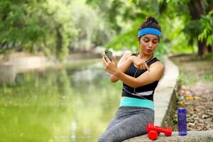 Physical Fit Woman Pointing Finger At Dumbbell photo