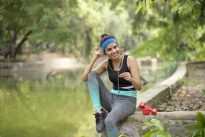 Asian Fit Woman Using Earphones And Listening Music photo