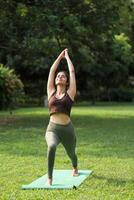 Front View Of Beautiful Woman Doing Yoga In Park photo