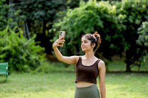 Nice Looking Woman Taking Selfie In Park photo