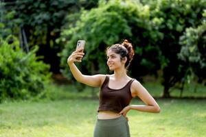 Nice Mature Woman In Gym Outfit Taking Selfie In Park After Exercise photo