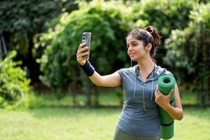 Gym Outfit Woman Taking Selfie In Park photo