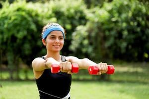 Close Up View Of Skinny Sexy Woman Holding Dumbbells In Hand photo