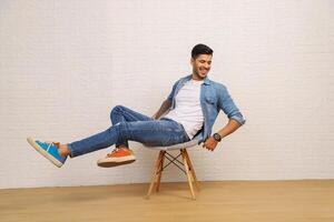 A Young Man Is Smiling While Lying On A Stool Raising His Leg photo