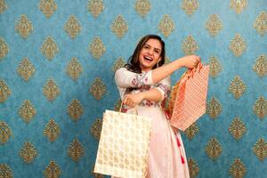 A Cheerful Woman Is Enjoying While Posing With Shopping Bags In Her Hands photo