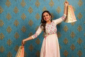 A Beautiful Woman With Shopping Bags Spreading Her Arms While Posing And Smiling photo
