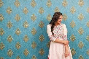 A Young Charming Woman In An Indian Outfit Is Posing While Smiling photo