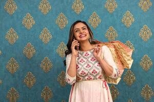 An Elegant Woman Is Smiling While Talking And Posing With Shopping Bags photo