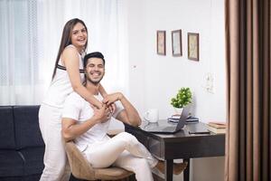 Picture Of Hot Couple In Casual Wear Sitting In Living Room While Posing In Front Of Camera photo