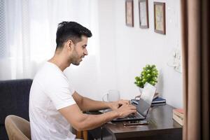 Man Using Laptop While Working At The Home Office photo