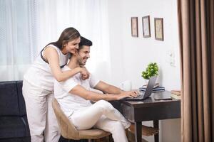 Stylish Couple Smiling While Looking At Laptop Screen photo