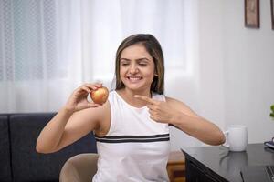 Joyful Woman In White Outfit Pointing Her Finger At Apple photo