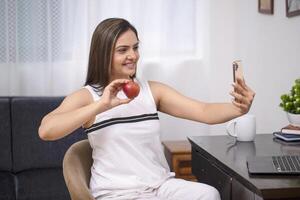 Asian Cute Woman In White Outfit Showing Apple On Call photo