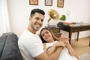 Young Couple Holding Hands And Smiling While Looking At Camera photo