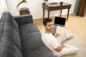 Handsome Indian Man Smiling While Turning Back While Holding Book In Hand photo