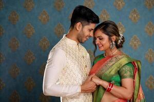 A Romantic Indian Couple In Traditional Attire Posing In Front Of The Camera photo