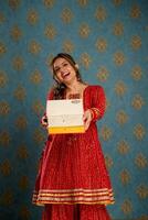 Smiling Asian Girl In Red Colour Dress Holding Gifts In Hands During Diwali Festival photo