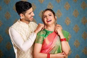 A Newly Married Indian In Traditional Outfits Gifts A Necklace To His Wife photo