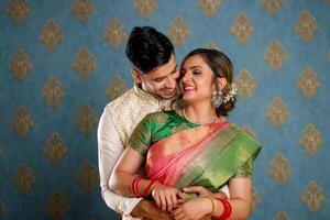 linda amor Pareja en tradicional trajes en pie abrazando en frente de el cámara foto