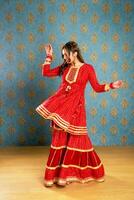 Image Of A Traditional Girl In A Red Suit Dancing In Front Of The Camera photo