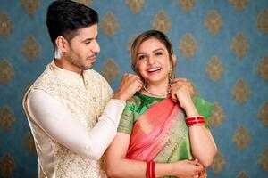 Image Of A Cute Indian Couple Presenting Wife Necklace photo