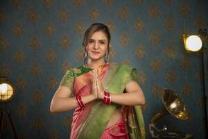 A Sweet Lady In Traditional Attire During Diwali Festival Showing Namaste Gesture In Front Of The Camera photo