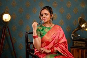 Beautiful Indian Model In Saree Sitting On Chair photo