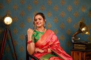 Hottest Female Model Seated On Chair Posing For The Camera While Wearing Traditional Attire For Diwali Festival photo