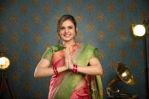 elegante dama en tradicional indio trajes durante diwali festival saludo con namaste gesto foto