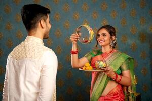 joven asiático Pareja vistiendo tradicional indio traje celebrando el karwa chauth festival foto