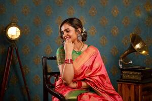 parte superior asiático modelo en sari sentado en un silla durante el diwali festival foto