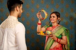 imagen de joven linda Pareja en tradicional indio atuendo celebrando karwa chauth festival foto