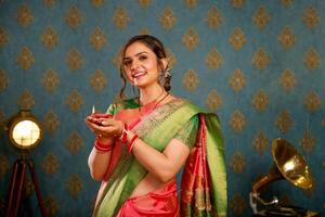 hermosa caliente modelo en sari participación diya en su mano foto