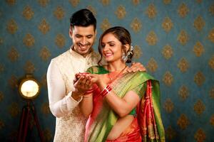 Picture Of A Happy Couple In Traditional Indian Attire At The Diwali Festival, Both Holding A Diya photo