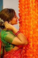 Image Of Mature Housewife In Saree Posing Gazing At The Floral-Decorated Wall photo