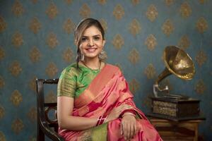 A Young Female Model Sitting On Chair In Saree For Diwali Festival photo