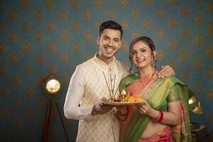 A Young Couple Enjoying Themselves While Holding Shopping Bags And Sitting On A Chair In Front Of The Camera photo