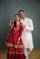 Picture Of An Adorable Couple Wearing Traditional Indian Attire Holding A Plate Of Ladoos In Their Hands And Smile photo