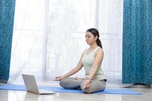mujer meditando en frente de ordenador portátil a hogar foto