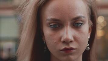 Portrait of a young attractive caucasian woman close up standing on a city street, raising her head, looking at the camera and feeling confident video