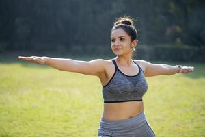 Indian Sports Woman Practicing Yoga Warrior Pose photo