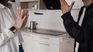 Close-up of male and female hands of a couple quarrelling and gesticulating in the kitchen at home. Concept of difficulties in the relationship video