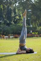 Classy Elegant Woman Doing Salamba Sarvangasana photo