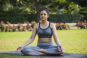 Super Fit Woman Meditating in the City Park photo