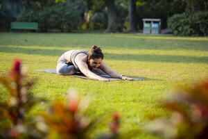 Cute Young Woman in Seated Forward Bend Pose photo