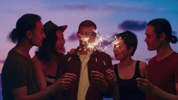 jovem amigos gastos Tempo junto, em pé com estrelinhas e falando fechar acima durante a ao ar livre festa com uma espetacular crepúsculo céu Como uma pano de fundo. conceito do despreocupado verão Diversão video