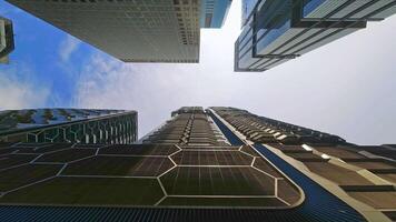 Walking camera straight up through modern skyscraper buildings with blue sky. POV view of city skyline buildings. Modern business district video