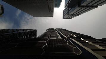 Gehen Kamera Gerade oben durch modern Wolkenkratzer Gebäude mit Blau Himmel. pov Aussicht von Stadt Horizont Gebäude. modern Geschäft Kreis video